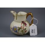 A Royal Worcester squat baluster jug, Design No 1138, decorated with violets and other flowers on an
