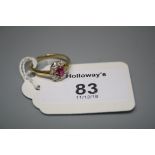 A ruby and diamond cluster ring, the oval cut ruby in claw mount above a border of old brilliant cut