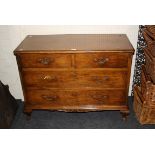 A French figured walnut chest of two short over two long drawers with cabriole legs and carved