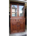 A Victorian pitched pine bookcase cabinet, the moulded cornice over a pair of glazed doors enclosing