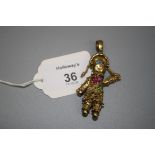 An articulated 9ct gold rag doll pendant set with multi-coloured stones