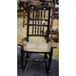 An Edwardian Lancashire-type triple spindle back rocking armchair, with rush seat