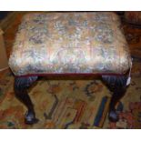 A Victorian oak footstool, the floral tapestry print upholstered seat on cabriole legs with leaf