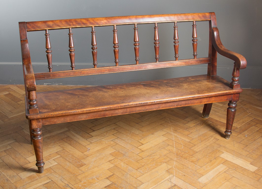 A Victorian mahogany hall seat, the channelled rail over generous spindle splats and downswept