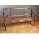 A Victorian mahogany hall seat, the channelled rail over generous spindle splats and downswept