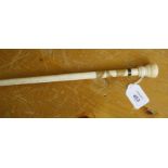 A 19th century dandy cane, the ivory knop handle over a horn inlaid neck and tapering bone shaft,