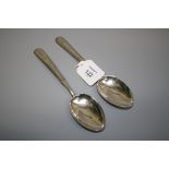 A pair of early 20th century Chinese silver dessert spoons, each with trailing leaf decorated