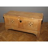 An Arts and Crafts pine coffer, the rectangular hinged lid over pierced sides and twin lockable