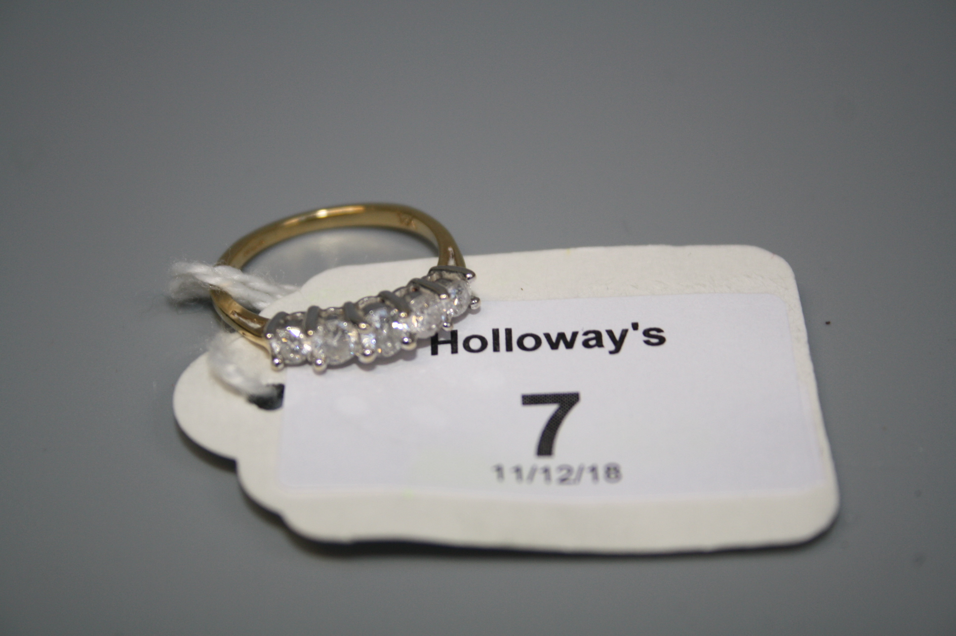 A five stone half hoop diamond ring, the slightly graduated brilliant cut diamonds in raised claw