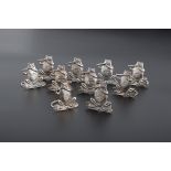 P.J.M. a set of ten silver place name/menu holders, each modelled a flute playing frog, cross legged