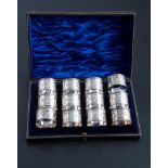 A cased set of twelve silver serviette rings, each engraved with floral reserves around vacant