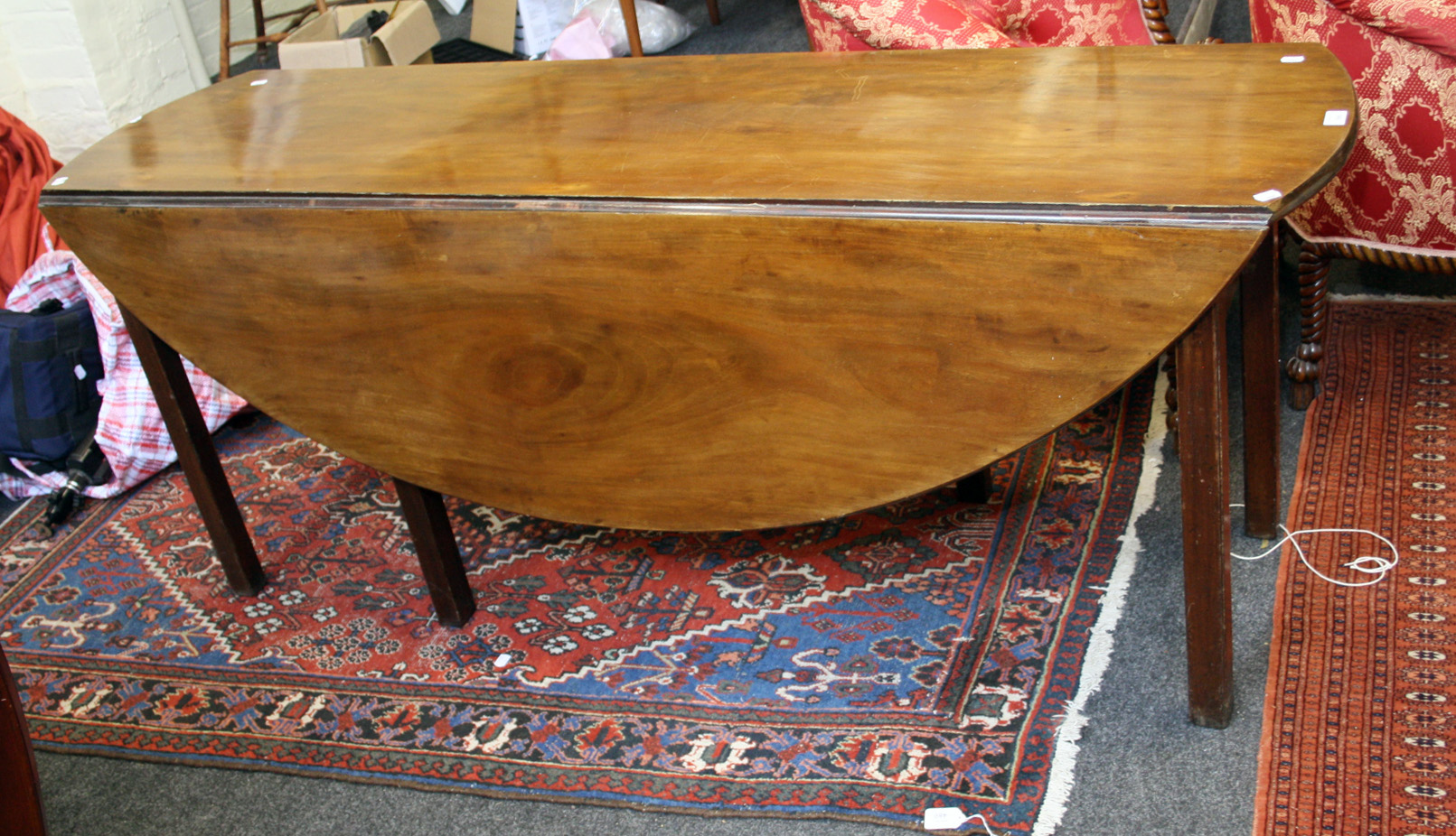 A George III mahogany Irish wake table of oval form with squared supports, 178cm long