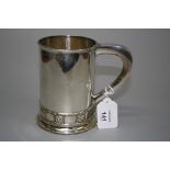 A.E. Jones, a cylindrical silver loop handled tankard with band of square rosettes over base rim,