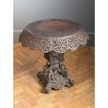 A 19th century Anglo-Indian heavily carved padouk wood occasional table, the circular top and