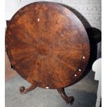 A Victorian figured mahogany circular breakfast table, with massive scroll supports, 132cm diameter