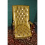 A 20th century green buttoned hide upholstered library armchair on ring turned forelegs and brass