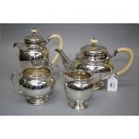 A 1920s silver four piece tea set of ovoid form with chased banded decoration and ivory fittings,