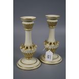 A pair of Royal Worcester ivory and gilt ground table candlesticks, each with gadrooned sconce and