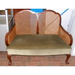 A two seater bergere style settee with cabriole su