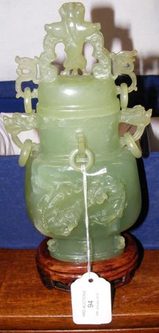 A carved jade pot and cover with wooden stand in f