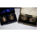 Two sets of cased silver napkin rings
