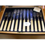 A set of silver fish knives and forks in presentat