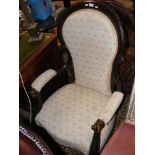 A 19th century easy chair with scroll armrests