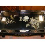 An oriental coffee table with decorative stone rel