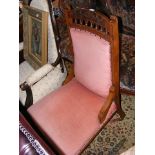 An Edwardian easy chair with carved backrest