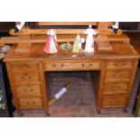 An Edwardian pedestal desk with nine drawers to th