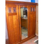 An antique triple robe with mirrored centre door -