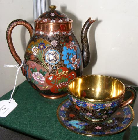 A decorative cloisonne teapot and matching cup and