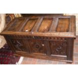 An antique carved coffer with panelled front