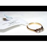 An 18ct gold three stone diamond ring - Size M