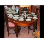 An antique extending mahogany dining table with tw