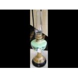 A Victorian oil lamp with green glass reservoir