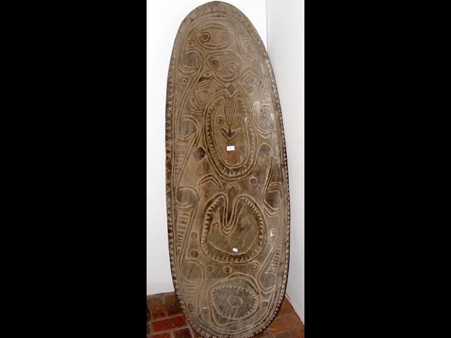 A large carved wooden war shield from the Sepik re