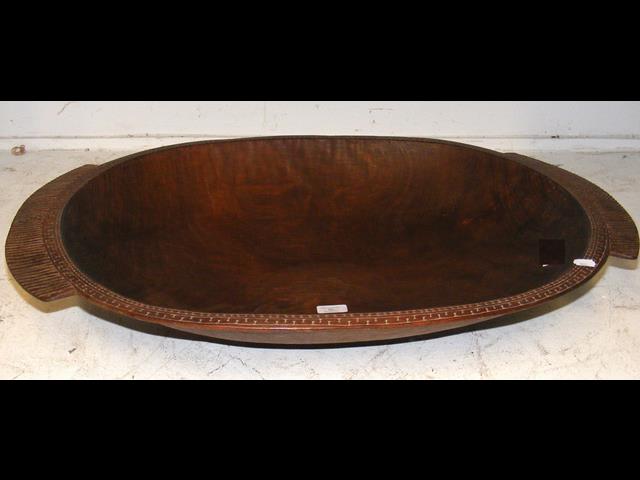 A large carved wooden food bowl from the Trobriand