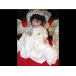 An antique bisque head doll with rolling glass eye