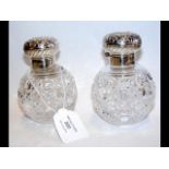 A pair of silver lidded cut glass globular scent b