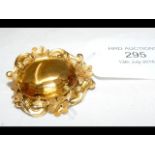 A citrine brooch in yellow metal setting