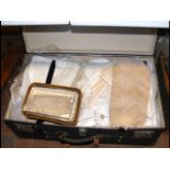 An old suitcase containing collectable linen and l