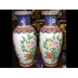 A pair of 64cm high oriental style vases with flor