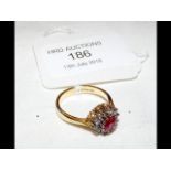 A ruby and diamond cluster ring in gold setting