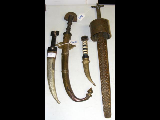 Three Middle Eastern daggers, together with a swor