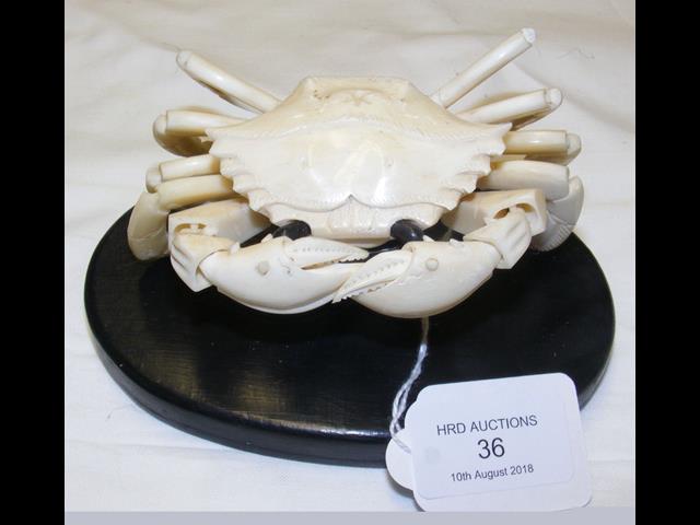 A carved oriental ivory articulated crab on wooden