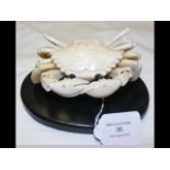 A carved oriental ivory articulated crab on wooden