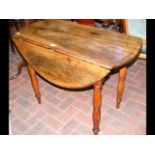 An antique country drop-leaf table on turned suppo