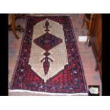 An old Persian woollen rug with geometric border a
