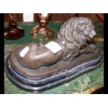 A 28cm long bronze style Lion on marble plinth